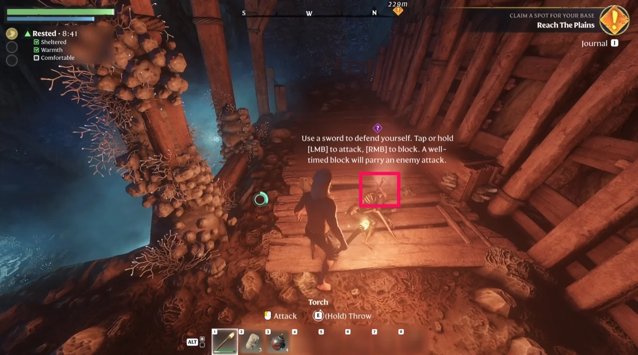 The cave interior with the sword pickup highlighted and the on-screen combat instructions